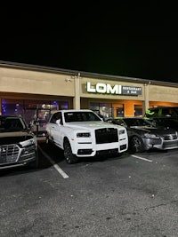 a group of cars parked in front of a building at night