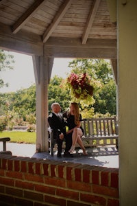 a man and woman sitting on a bench in a gazebo