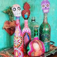 a group of colorful wine bottles with skulls on them