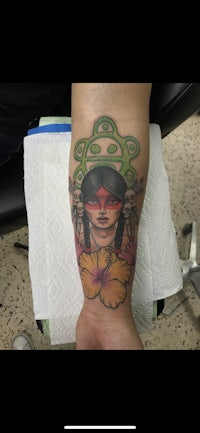 a tattoo of a woman with a flower on her arm