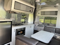 the interior of an rv with a kitchen and dining area