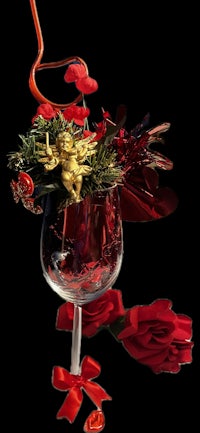 a red wine glass with red roses and a bow