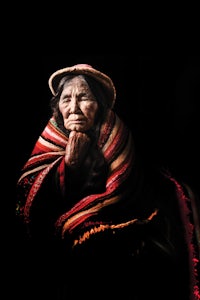 an old woman wearing a hat and a blanket