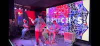 a group of people playing music in front of a large screen