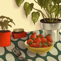 a bowl of strawberries on a table next to a potted plant
