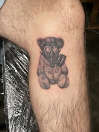 a man with a teddy bear tattoo on his leg