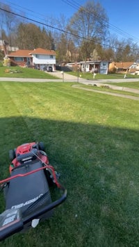 a lawn mower in the middle of a grassy yard