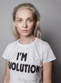 a woman wearing a white t - shirt that says i'm evolution