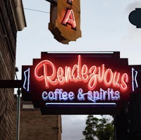 a neon sign that reads rendevous coffee & spirits