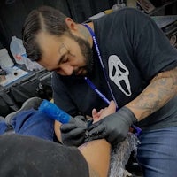 a man getting a tattoo at a convention