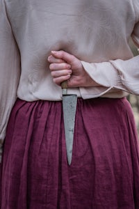 a woman wearing a skirt with a knife on her back