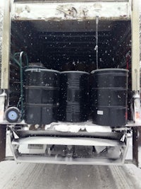 the back of a truck with barrels in the snow