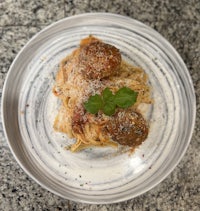 a plate of spaghetti with meatballs and parmesan