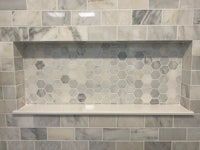 a bathroom with a white and gray tiled wall