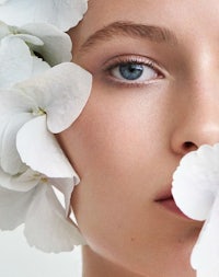 a woman with white flowers on her face