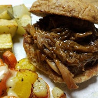 a pulled pork sandwich with mashed potatoes and carrots