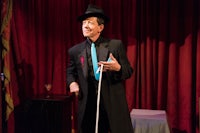 a man in a hat and tuxedo holding a cane