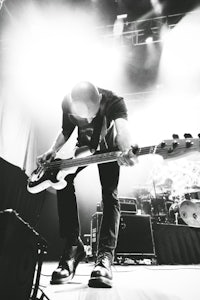 a black and white photo of a man playing a bass