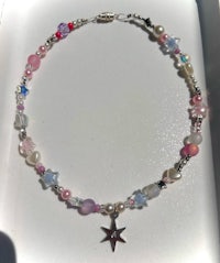 a bracelet with a star and pink beads