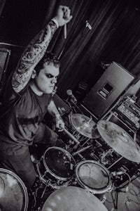a black and white photo of a man playing drums