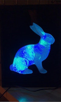a blue rabbit is lit up in a black frame