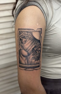 a tattoo of a woman with a sun on her arm
