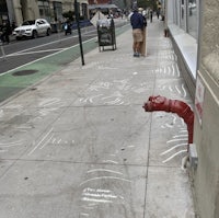 a sidewalk with a red fire hydrant painted on it