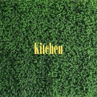 a green wall with the word kitchen on it