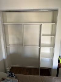 a white closet with shelves and drawers in it