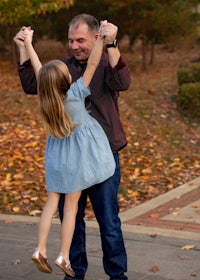 a man is holding a little girl up in the air