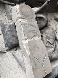 a statue of a man sitting in a pile of rubble
