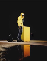 a man in a yellow jacket standing in a puddle
