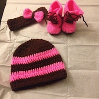 a crocheted hat, booties and booties are on a table