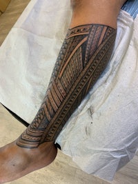 a man's leg with a tribal tattoo on it