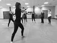 a group of women practicing martial arts in a gym
