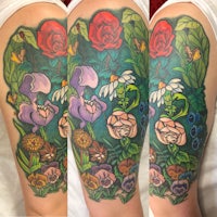 a colorful tattoo of flowers on a person's sleeve