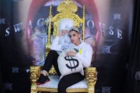 a woman sitting on a gold throne with a bag of money