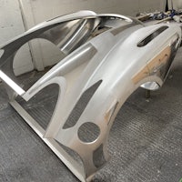 a silver car is being made in a workshop