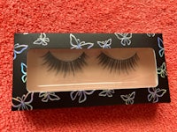 a pair of false eyelashes in a box with butterflies on it
