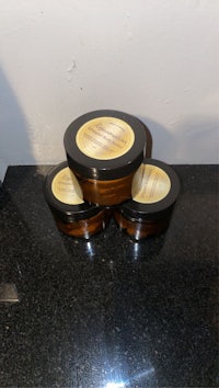 three jars of body butter sitting on top of a counter