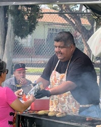 a man is handing out food to a woman