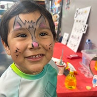 a young boy with a cat face painted on his face