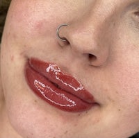 a close up of a woman's lips with piercings