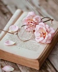 pink roses and glasses on an open book