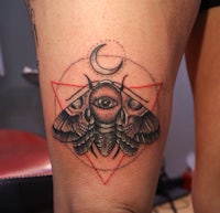 a tattoo of a moth with a crescent moon