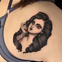 a black and white tattoo of a woman with long hair