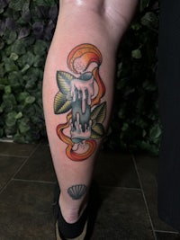 a woman's leg with a colorful tattoo on it