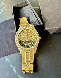 a gold watch with diamonds in a box