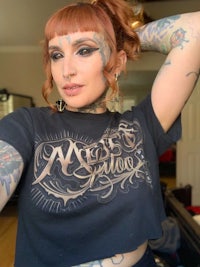 a woman with tattoos posing in front of a mirror
