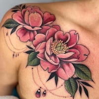 a woman with a pink flower tattoo on her chest